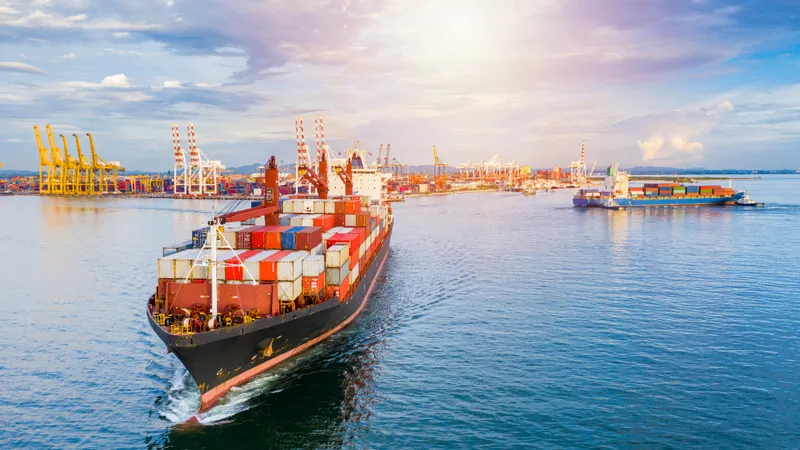 Buque portacontenedores navegando hacia un puerto de carga con grúas pórtico